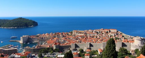 Wide view towards the old town of Dubrovnik, with sea behind and blue skies and sunshine in Croatia