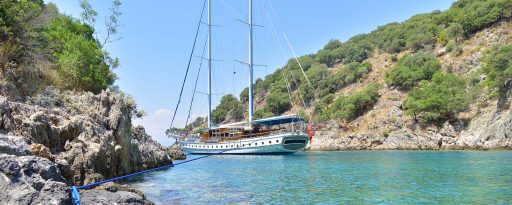 A gulet tied up in a cove as seen from the shore on the coast of Turkey