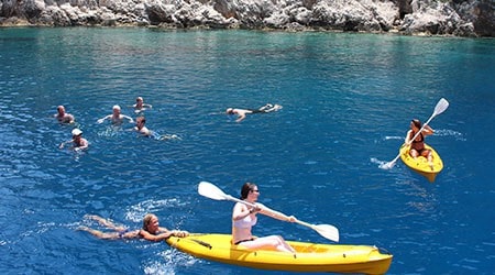 Families swimming, kayaking and playing in the sea on a gulet vacation
