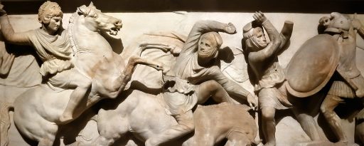 Wide section of the Alexander sarcophagus in Istanbul archaeological museum focusing on Alexander the Great on horseback charging into battle against a Persian cavalryman who is falling