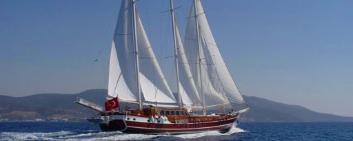 The Gulet Dolce Vita sailing away from camera with the coast of Croatia in the background