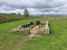 An archaeologist guide showing a group around the temple of Mithras on Hadrian's Wall in England