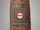 A tall rectangular Roman shield of the type associated with legionaries and known as a 'scutum'. It is richly and busily painted, primarily in a warm Pompeian red