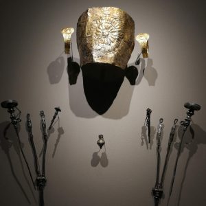 Detail from the display of (female) Grave 505, apparently with an unusual preference for silver. The earrings are made of gold, as is the pendant, while the decorated sheet covering the face is of gilded silver. The pins and other ornaments are all silver. Circa 520/510 BC.