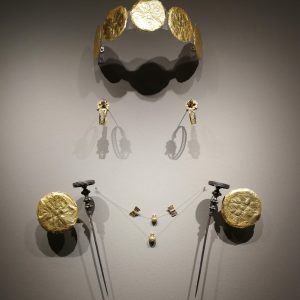 Head and body ornaments from (female) Grave 688, including an elaborate gold diadem, intricate earrings (note the shadows), a necklace with sheet gold shaped as two vases and two double axes, gold rosettes and two elaborate silver pins. Circa 525-500 BC.