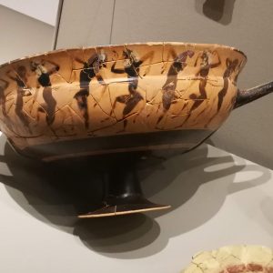 Athenian black-figure cup from (female) Grave 738, depicting a group of dancing satyrs. The hand has been identified as that of the C-Painter, who was active before 550 BC. Since the rest of the items are dated between 525 and 500 BC, this object may have been an heirloom.