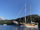 Gulet and sail boat anchored at Gemiler island on the Lycian coast of Turkey. Ruins can be seen projecting out of the trees on the island.