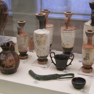 Grave offerings from the grave of Eupheros, including numerous aryballoi (oil containers), an oinochoe (wine jug) and a strigil like the one he is seen holding on his sculpted grave stele. Kerameikos Museum.