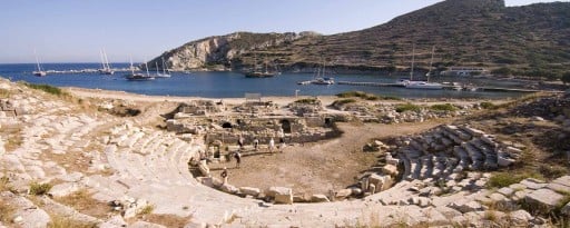 looking over the ancient theatre and a small group of visitors out towards the historic commercial harbour at the archaeological site of Knidos on the Carian coast of Turkey
