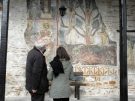 Nota Karamaouna, a Byzantine art historian and licenced Greek guide discussing the frescoes on the external façade of the Mavriotissa in Kastoria, Greece, with the local caretaker