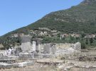 Monument in the centre of ancient Messene, with the village of Mavromati in the background. In the Peloponnese in Greece.