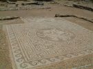 The andron of house vi 3 at Olynthos in Macedonia (northern Greece). A wonderful 4th century BC pebble mosaic of Bellerophon occupies the centre, but the surrounding space is left undecorated, as it held the klinai (feasting couches). (Image by Christaras A, Wikimedia Commons.)