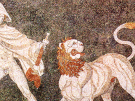 A mosaic of light pebbles on a dark background from Pella in Macedonia, the birthplace of Alexander the Great, showing Alexander hunting a lion, the lion with an open mouth turns its head towards the left.