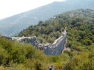 Section of the ancient Roman Delikkemer Aqueduct on the Lycian Way, Turkey, showing its unique stone-pipe wall design stretching across a lush valley