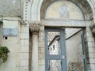 A stone archway entrance to the Euphrasian Basilica in Poreč, featuring a golden Byzantine mosaic in the lunette above the door. To the left, a marble street sign identifies the location as Ulica Eufrazijeva (Euphrasian Street).