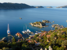 Aerial view of Kale harbour from the castle at Simena looking towards Kekova island, Turkey, featuring docked boats and a gulet, turquoise waters, and lush green hills