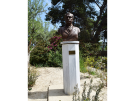 The bronze monument bust of Minos Kalokairinos, a Cretan amateur archaeologist, standing on a white marble pedestal at the Palace of Knossos in Crete.