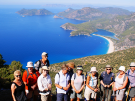 View of the Blue Lagoon in Ölüdeniz, Turkey, showing the white sand beach, turquoise waters, and surrounding green mountains.