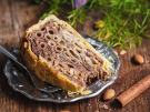 A slice of Stonska torta, a traditional Croatian macaroni cake, showing the unique cross-section of pasta tubes filled with a walnut and chocolate mixture on a silver plate.