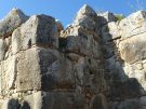A masonry bastion or tower-like structure jutting out from a curtain wall of roughly squared-off large blocks in the ancient site of Tiryns in Greece